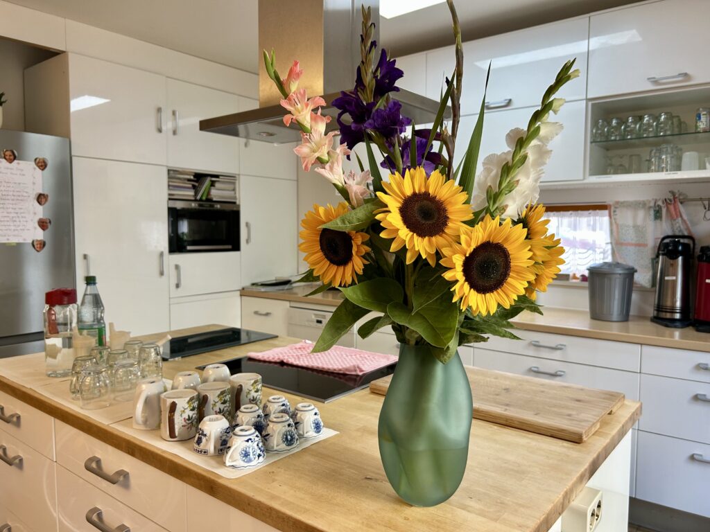 Blick in die WG-Küche; im Vordergrund Blumen